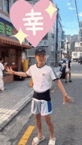 a boy wearing a white adidas shirt is standing on a street