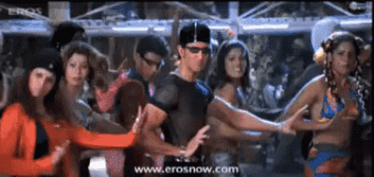 a group of people are dancing in front of a screen which says erosnow.com