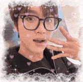 a young man wearing glasses and a black jacket has hearts around his face