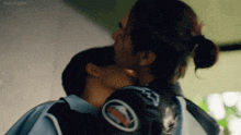 a man and a woman are hugging and kissing .