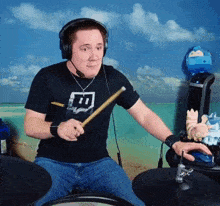 a man wearing headphones and a black shirt with the number 11 on it is playing drums