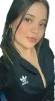 a woman wearing a black adidas jacket is taking a selfie