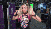 a woman in a wrestling outfit is standing in front of a green screen with the number 13 on it