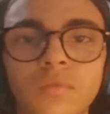 a close up of a person wearing glasses making a face .