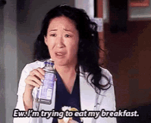 a woman in a lab coat is holding a bottle of water and says ew i 'm trying to eat my breakfast