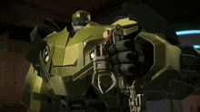 a robot with blue eyes is holding a gun in his hand .