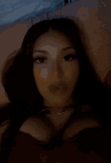 a woman is laying on a bed with a butterfly on the pillow and taking a selfie .