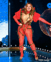 a woman in a red and gold costume is dancing on a stage with t4yce tumblr in the corner