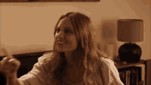 a woman is sitting on a couch with a lamp in the background .
