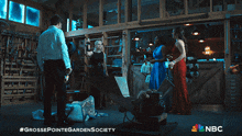 a group of people are standing in a room with a nbc logo on the bottom