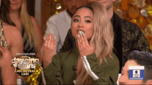 a woman sitting in front of a dancing with the stars cast reveal live