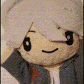 a close up of a stuffed animal with a smiling face and gray hair .