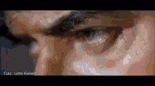 a close up of a man 's eye with a black eyebrow and a white eye .