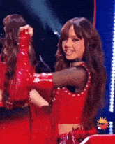 a woman in a red outfit is smiling and dancing