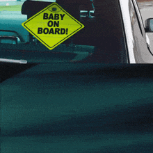 a yellow sign that says baby on board on a car window