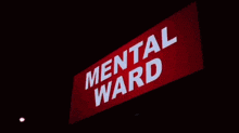a man is walking down a hallway in a hospital while carrying a stretcher .
