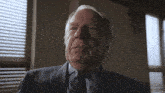 a man in a suit and tie looks up at the camera