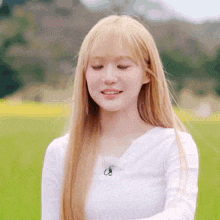 a girl with long blonde hair and bangs is wearing a white shirt