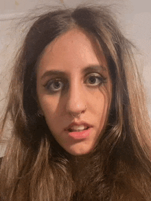 a woman with a nose ring looks at the camera with a serious look on her face