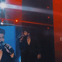 a man with a beard is standing in front of a flame coming out of his mouth .
