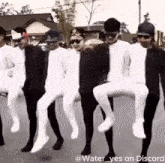 a group of men in white tights are dancing on a street ..