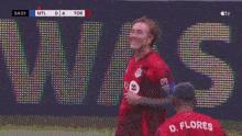 a soccer player with the number 20 on his back is hugging his teammates