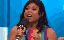 a woman singing into a microphone with the letters o and s on it