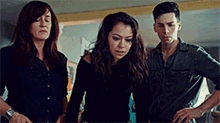 a man and two women standing next to each other in a room