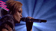 a woman is singing into a microphone with a nokia.com logo in the background
