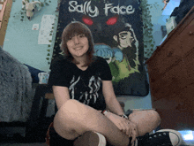 a girl sits in front of a sally face poster
