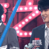 a man in a suit and tie is smiling in front of a sign that says ' 11.11 '