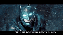 a close up of a man in a batman armor with the words tell me does your butt bleed on the bottom