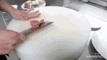 a person is cutting a piece of meat on a white cutting board made by animatica