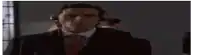a man in a suit and tie with headphones on