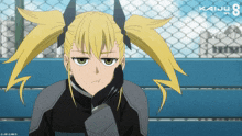 a girl with pigtails is sitting on a bench with the number 8 on the fence in the background