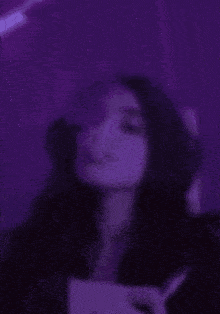 a blurry picture of a person smoking a cigarette in a dark room .