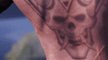 a close up of a person 's back with a tattoo of a skull