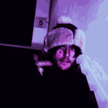 a man wearing a fur hat is standing in front of a door with the number 5 on it