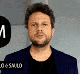a man with a beard is wearing a blue jacket