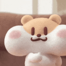 a stuffed animal bear with a mustache is standing on a couch .