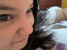 a close up of a woman 's face with a white shirt on