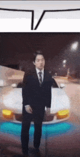 a man in a suit and tie is standing next to a white car
