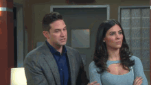 a man and woman are standing next to each other in a room