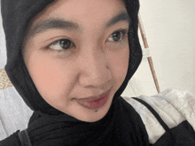 a woman wearing a black hijab with a white stripe on the sleeve