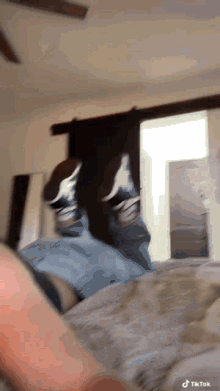 a person is laying on a bed with their feet up and a tiktok watermark