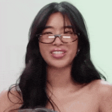 a close up of a woman wearing glasses and making a face .