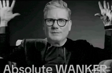 a black and white photo of a man with glasses and the words absolute wanker on the bottom