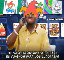 a man in a yellow shirt is talking on a cell phone in front of joker playing cards