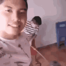 a man is standing next to a boy holding a broom .