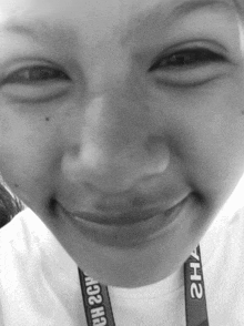 a girl wearing a lanyard that says yh2 smiles for the camera